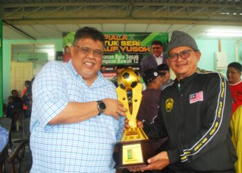 AB. RAUF Yusoh menyerahkan piala yang disumbangkan kepada penganjur selepas merasmikan Kejohanan Bola Sepak Perempuan Bawah 12 tahun Peringkat Negeri di SK Datuk Tambichik Karim, Alor Gajah, Melaka. - UTUSAN/AMRAN MULUP