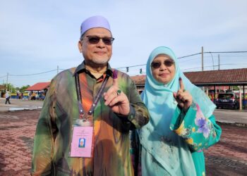 MOHD. Amar Nik Abdullah (kiri) bersama isteri menunjukkan jari yang sudah dicelup dengan dakwat tanda selesai menjalankan tanggungjawab mengundi di SK Panji di Kota Bharu, Kelantan hari ini. UTUSAN/MUSTAQIM MOHAMED