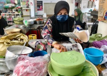 RAHIMAH Hasan membungkus kuih lompat tikam untuk pelanggan di Pasar Berek 12, Kota Bharu, Kelantan semalam. – UTUSAN/ROSLIZA MOHAMED