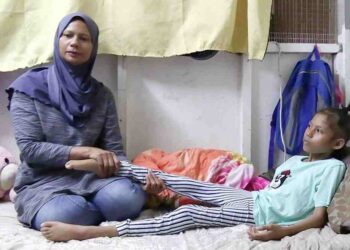 DAYANG Suhana Abdullah (kiri) tabah menjaga Intan Nur Dayana Mohd. Jusuh (kanan) yang memerlukan penjagaan rapi kerana kesukaran untuk berjalan selepas disahkan menghidap kanser saraf tunjung tahap tiga. - UTUSAN/DIANA SURYA ABD WAHAB
