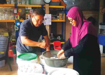 NORDIN Hamid bersama Noorsham Abdullah menyusun telur untuk diproses menjadi telur masin dan ia dilakukan dekat rumahnya sendiri di Klang, Selangor. – UTUSAN/ABDUL RAZAK IDRIS