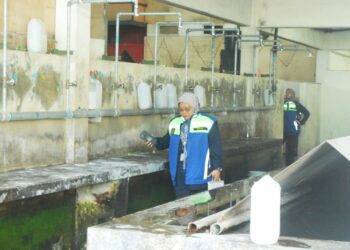 PENGUATKUASA JTK melihat ruang mandi yang kotor dan berlumut di sebuah gudang di Kawasan Perindustrian Bukit Rambai, Melaka. - UTUSAN/AMRAN MULUP