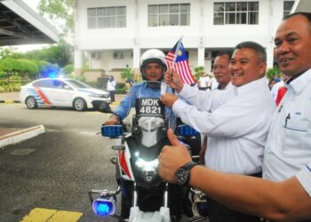 RAIS Yasin melekatkan Jalur Gemilang di sebuah motosikal selepas pelancaran Program Kibar Jalur Gemilang Peringkat MBMB 2023. - UTUSAN/AMRAN MULUP