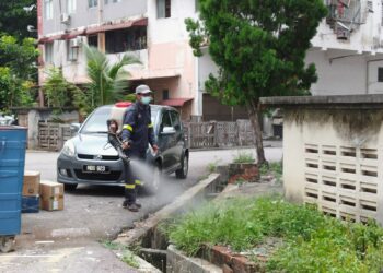 KAKITANGAN Jabatan Kesihatan Negeri sedang melakukan kerja penyemburan nyamuk di sekitar kawasan Pangsapuri Kota Laksamana, Kota Laksamana, Melaka. - UTUSAN/MUHAMMAD SHAHIZAM TAZALI