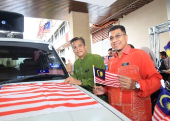 ZAINI Hussin (kiri) memasang Jalur Gemilang pada kenderaan sempena Majlis Sambutan Jalur Gemilang Peringkat Wisma di perkarangan Wisma Persekutuan, Kota Bharu, Kelantan hari ini-KAMARUL BISMI KAMARUZAMAN