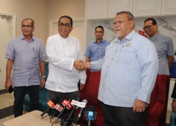 MOHAMAD Khaled Nordin bersalaman dengan  Aminolhuda Hassan pada  sidang media selepas  menghadiri Mesyuarat Khas Umno Johor dan Parti Amanah Johor menjelang PRK di Pejabat Badan  Perhubungan Umno Johor, Johor Bahru disini. -UTUSAN/RAJA JAAFAR ALI.
