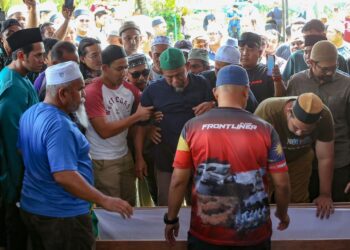 MUHAMAD Saleh Othman hiba ketika melihat jenazah anaknya yang sedang diturunkan ke liang lahad di Tanah Perkuburan Islam Masjid Al-Huda Kampung Jerung, Sungai Petani. -UTUSAN/SHAHRIR NOORDIN