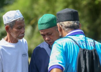 MUHAMAD Saleh Othman ditenangkan saudara mara ketika mengiringi jenazah anaknya yang dibawa ke Tanah Perkuburan Islam Masjid Al Huda di Kampung Jerung, Sungai Petani. -UTUSAN/SHAHIR NOORDIN