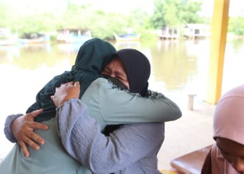NIK Suliana Bikri Kamal (kanan) dipeluk oleh ahli keluarga semasa berada di Jeti Lembaga Kemajuan Ikan Malaysia Kuala Kemasin, Bachok, Kelantan-UTUSAN/ROHANA MOHD. NAWI.