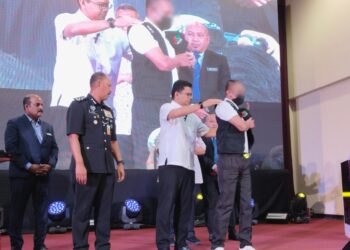 AKMAL NASRULLAH Mohd. Nasir (dua dari kanan) memakaikan ves kepada seorang perantis Program Sinar Di Sebalik Tirai Besi: Inisiatif Pensijilan Kemahiran Malaysia Bidang Pengurusan Sisa Pepejal dan Pembersihan Awam di Kompleks Penjara Melaka, Sungai Udang, Melaka. - UTUSAN/MUHAMMAD SHAHIZAM TAZALI