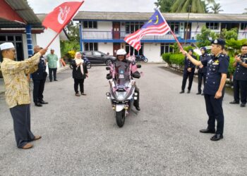 AMRAN Dollah (kanan) bersama Mohd. Rusli Abdullah melakukan pelepasan Kembara Solo Halim Hamid mengelilingi Semenanjung Malaysia sempena sambutan kemerdekaan negara di Balai Polis Wakaf Bharu, Tumpat, Kelantan hari ini-UTUSAN/ROHANA ISMAIL