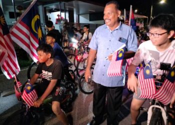 S. Jeganathan bersama kanak-kanak yang turut serta dalam perarakan ambang merdeka di Taman Bakri Jaya, Muar, Johor. - ADNAN IBRAHIM