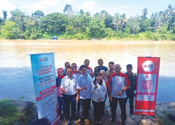 LEONG YU MAN (depan, tengah) dan Zahid Ahmad Zawawi (dua dari kanan) bersama kakitangan Agrobank serta Bank Negara Malaysia selepas pelancaran Program Kampung Cashless Mukim Ulu Tembeling di Kampung Bantal, Jerantut, semalam.