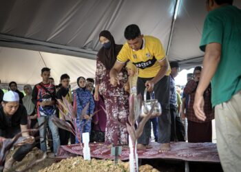 BALU Allahyarham Sharipuddin Shaari, Suriana Muda bersama dua anak, Muhammad Sharul Izuan dan Nur Izzara Arissya  menyiram air di pusara suaminya yang selamat dikebumikan di Tanah Perkuburan Masjid Sultan Hisamuddin, Bandar Baru Salak Tinggi (BBST), Sepang. - UTUSAN/FAIZ ALIF ZUBIR