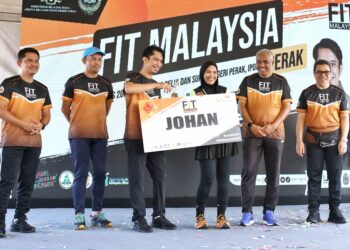 ADAM Adli Abdul Halim (tiga dari kiri) menyampaikan hadiah kepada Azlina Mohd Ali, pemenang acara larian 10 kilometer Program Fit Malaysia Peringkat Negeri Perak di Ipoh. - UTUSAN/MUHAMAD NAZREEN SYAH MUSTHAFA