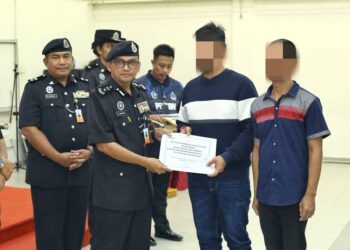 KAMARUL Alam Taib menyerahkan dokumen PBSL sempena Sambutan Hari Kebangsaan kepada penghuni penjara Tapah hari ini. - UTUSAN/MUHAMAD NAZREEN SYAH MUSTHAFA