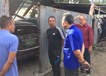 AHMAD Razif Abd. Rahman (dua kiri) bertanyakan sesuatu kepada Wan Nazari Wan Mohamad ketika melawat bengkel kenderaan yang terbakar di Lorong Wakaf Baru, Kampung Wakaf Tembesu, Kuala Nerus, hari ini. - UTUSAN/TENGKU DANISH BAHRI TENGKU YUSOFF