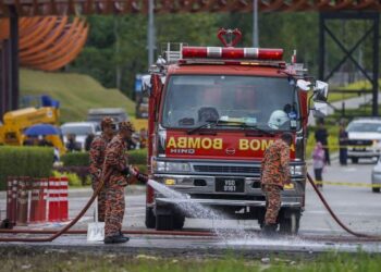 ANGGOTA bomba sedang melakukan kerja-kerja pembersihan di kawasan kejadian kapal terbang terhempas, di Elmina, Shah Alam, hari ini. - UTUSAN/SHIDDIEQIIN ZON