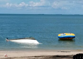 KEADAAN bot dinaiki sembilan individu termasuk tujuh pelancong tempatan yang terbalik di Pantai Teluk Batik, Lumut semalam. - UTUSAN