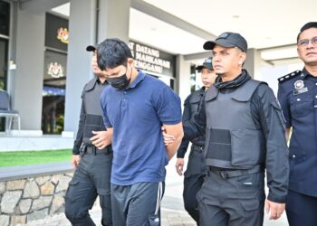 MUHAMMAD Hanif Mohd. Rosli (dua dari kiri) yang dituduh membunuh pemandu kereta sewa dibawa keluar dari Mahkamah Majistret Kuala Terengganu di Kuala Terengganu, hari ini. - UTUSAN/PUQTRA HAIRRY ROSLI