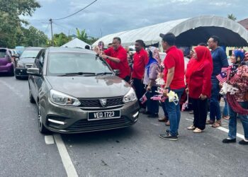 ROZABIL Abd Rahman (kiri) mengantung Jalur Gemilang pada salah sebuah kenderaan sewaktu Program Santuni Merdeka 2023 Parlimen Arau di hadapan Pejabat UMNO Bahagian Arau, Kampung Che Ok, Arau, Perlis hari ini.- UTUSAN/ASYRAF MUHAMMAD