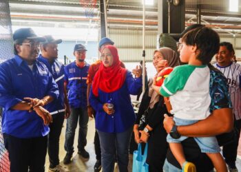 JOHARI Abdul Ghani (kiri) bersama Wan Zulaika Anua (tengah) mendekati penduduk pada Program Santai Futsal Anak Muda, di DMS Sport Beranang, Selangor. - UTUSAN/ SHIDDIEQIIN ZON