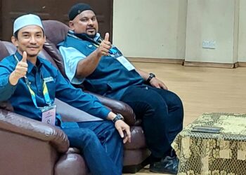 MOHD. YUSNI Mat Piah (kiri) bersama penyokongnya menunjukkan isyarat bagus selepas berjaya mempertahankan kerusi DUN Penaga pada PRN semalam.