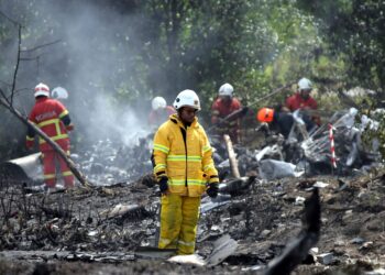 PASUKAN Bomba dan Penyelamat memeriksa keadaan bangkai pesawat yang hangus terbakar selepas terhempas di Persiaran Elmina, Seksyen U16 Shah Alam, Selangor, semalam. -UTUSAN/SADDAM YUSOFF