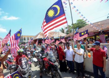 FAHMI Fadzil melepaskan flag off konvoi motorcross 'Cross Merdeka' pada Program Merdeka @Komuniti DUN Dengkil di Dengkil, Selangor. - UTUSAN/FAISOL MUSTAFA