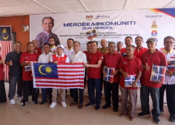 FAHMI Fadzil bergambar selepas menyampaikan Jalur Gemilang kepda ketua komuniti pada Program Merdeka @Komuniti DUN Dengkil di Dengkil, Selangor. - UTUSAN/FAISOL MUSTAFA