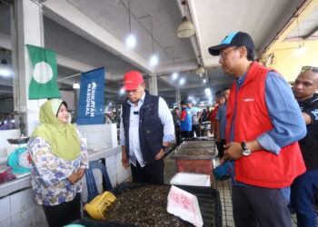 SAIFUDDIN Nasution Ismail (tengah) bersama Asmirul Anuar Aris bertanya khabar kepada peniaga di Pasar Besar Alor Setar.