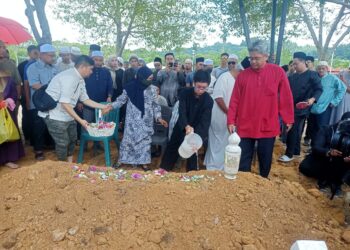 ANAK sulung arwah Heikal, Daniel Zulqarnain menyiram air mawar atas pusara arwah di Tanah Perkuburan Islam Putrajaya. - UTUSAN/MOHD HUSNI MOHD NOOR