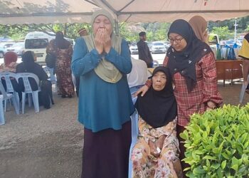 SUHARNALIZA Shaari (kanan) dan Hatun Bakar (duduk) menunggu ketibaan van jenazah di Masjid Ar-Rahimiah, Klang, Selangor, semalam. 
– UTUSAN/ISKANDAR SHAH MOHAMED
