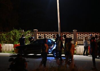 ANGGOTA polis memeriksa teksi milik mangsa, Mohd. Latif Idris yang ditemukan mati dalam kereta tersebut di Seberang Takir, Kuala Nerus, baru-baru ini. - UTUSAN/PUQTRA HAIRRY ROSLI
