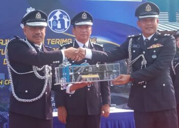MAZLAN Hassan (kiri) menerima tongkat kuasa daripada Superintenden Roslee Omar sempena majlis penerimaan tugas Ketua Polis Temerloh yang disaksikan oleh Yahaya Othman (tengah) di Temerloh, Pahang. - FOTO/HARIS FADILAH AHMAD
