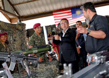 ADLY Zahari melihat peralatan ketenteraan yang dipamerkan pada Program Membudayakan R&D Pertahanan di SMK Durian Tunggal, Alor Gajah, Melaka. - UTUSAN/SYAFEEQ AHMAD
