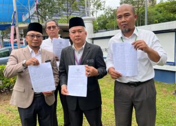 ABU Suffian Abu Yaziz (tengah) bersama Moiez Basri (kanan) menunjukkan salinan laporan polis di Ibu Pejabat Polis Daerah Putrajaya. - UTUSAN/KAMARIAH KHALIDI