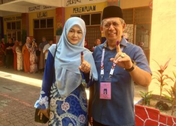 AHMAD Razif Abd. Rahman  bersama isteri, Halina Zakaria selepas membuang undi di SMK  Kompleks Seberang Takir, Kuala Nerus, hari ini. - UTUSAN/TENGKU DANISH BAHRI TENGKU YUSOFF  