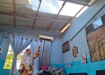 ZAINUN Abdul Rahman menunjukkan bumbung  rumahnya yang tercabut dalam kejadian ribut di Kampung Wakaf Merah, Tendong Pasir Mas, Kelantan-UTUSAN/ROHANA ISMAIL.