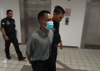 MOHD. Izzham Halim (kiri) yang mengaku salah menerima suapan dibawa keluar dari Mahkamah Sesyen di Kuala Terengganu, hari ini. - UTUSAN/TENGKU DANISH BAHRI TENGKU YUSOFF