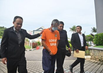 PEMBANTU kanan sebuah pihak berkuasa tempatan (PBT) yang disyaki melakukan salah guna kuasa dibawa di Mahkamah Majistret Kuala Terengganu, di Kuala Terengganu, hari ini. - UTUSAN/PUQTRA HAIRRY ROSLI     