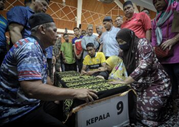 SURIANA Muda dan dua anaknya menatap jenazah Sharipuddin Shaari di Masjid Sultan Hisamuddin, Bandar Baru Salak Tinggi (BBST), Sepang. - UTUSAN/FAIZ ALIF ZUBIR