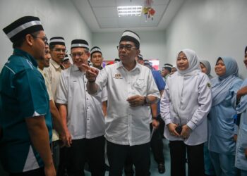MOHAMED Khaled Nordin (tengah) beramah mesra bersama kakitangan hospital selepas merasmikan Pengoperasian Klinik Pakar Hospital Pengajar Universiti Sultan Zainal Abidin (HPUniSZA) di Kampung Gong Badak, Kuala Nerus, hari ini. - UTUSAN/PUQTRA HAIRRY ROSLI