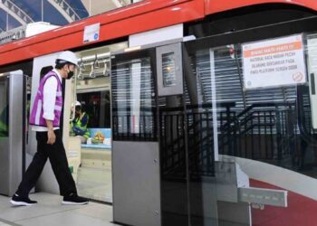JOKOWI perlu menunduk dan membongkokkan sedikit badannya untuk menaiki LRT ekoran pintu yang direka tidak mengikut piawaian antarabangsa. - AGENSI