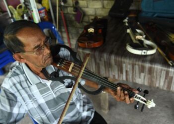 GESEKAN biola oleh Hashim Din atau lebih dikenali sebagai Pak Long,75, cukup merdu sekali gus memukau siapa sahaja yang mendengarnya di Kampung Kubang Gajah, Arau, Perlis semalam.- UTUSAN/IZLIZAN OTHMAN