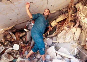 SEORANG penduduk mencari barangan yang masih boleh digunakan di celah runtuhan bangunan di Derna, timur Libya. - AFP