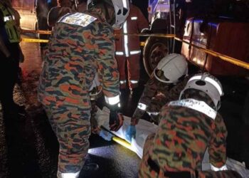 ANGGOTA bomba berusaha membawa keluar mayat mangsa yang masih berada di bawah lori yang terlibat kemalangan di Pasar Meludam, Saratok malam tadi.