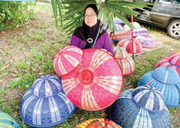 NASLINDA Abdullah menunjukkan hasil kerja tudung saji sulaman reben yang dijual di Jalan Stadium, Alor Setar, Kedah. – UTUSAN/JAMLIAH ABDULLAH