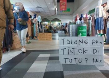 POSTER meminta kerajaan menutup TikTok Shop diletakkan di hadapan beberapa kedai di Pasar Tanah Abang di Jakarta Pusat.-AGENSI