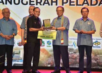 ABANG Johari Tun Openg (dua kanan) menyampaikan Anugerah Peladang Jaya kepada salah seorang penerima di Sarawak Agrofest, di Dataran Perayaan Jalan Stadium Petra Jaya Kuching hari ini..
